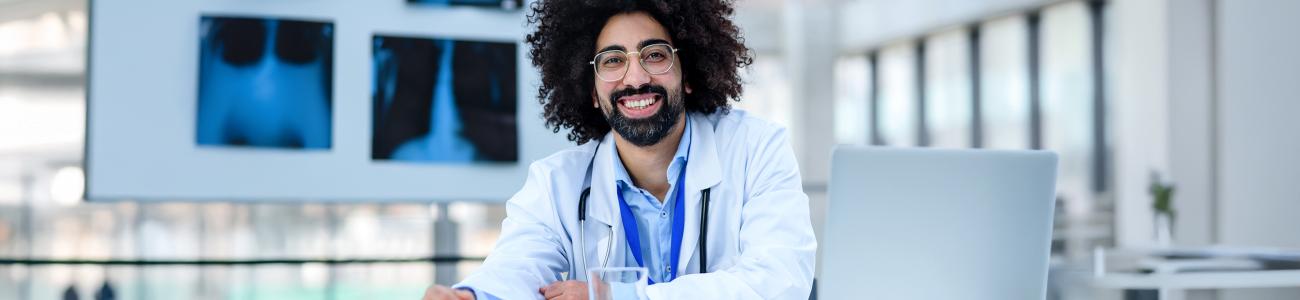 portrait of cheerful male doctor sitting In hospital