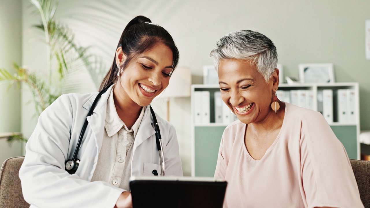 Happy, doctor and senior woman on tablet in office for good news, research and online results of di.
